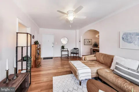 a living room with furniture and a large mirror with wooden floor
