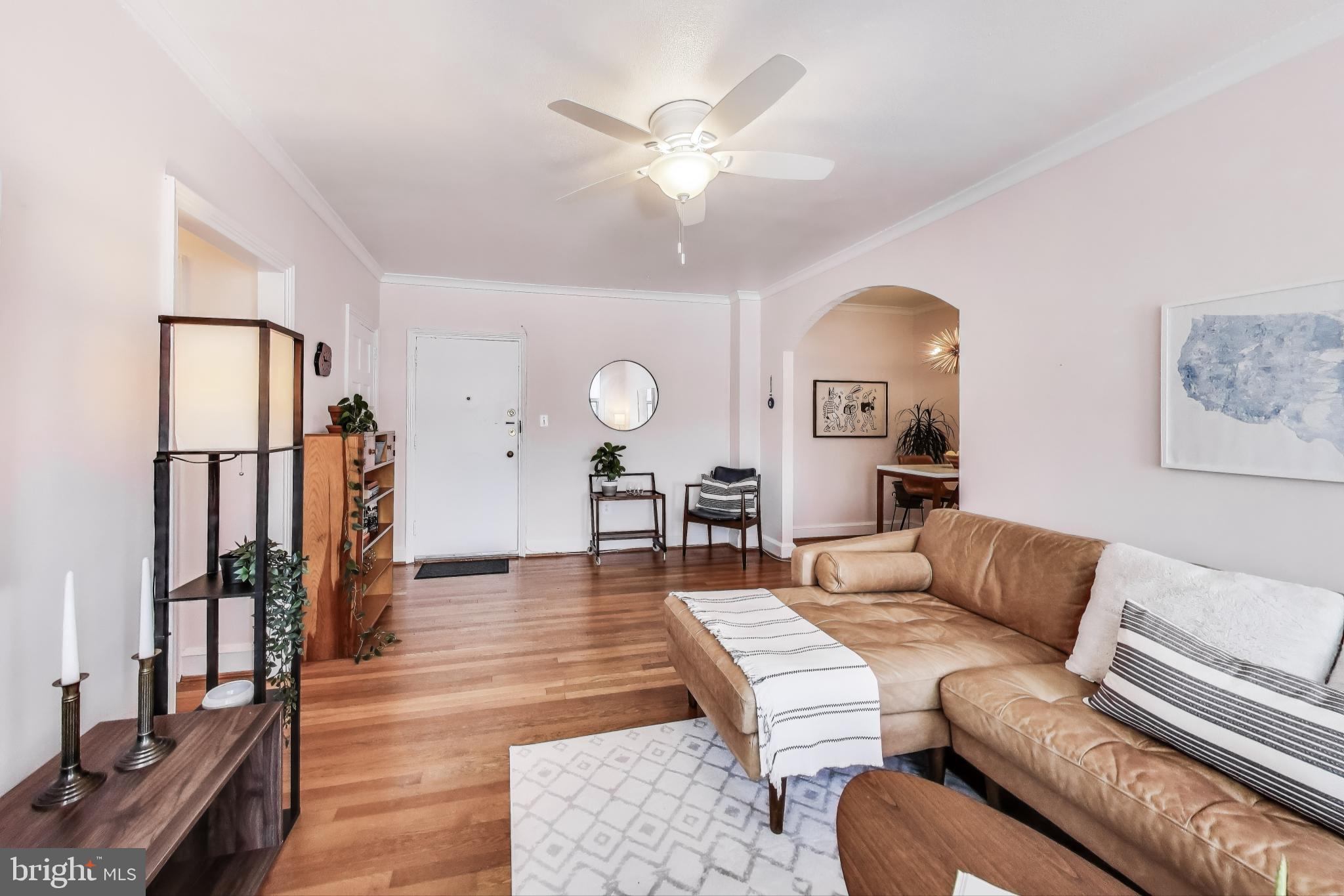 1365 Kennedy Street Northwest, Unit 506 Washington, DC 20011 - Photo 2 of 24 a living room with furniture and a large mirror with wooden floor