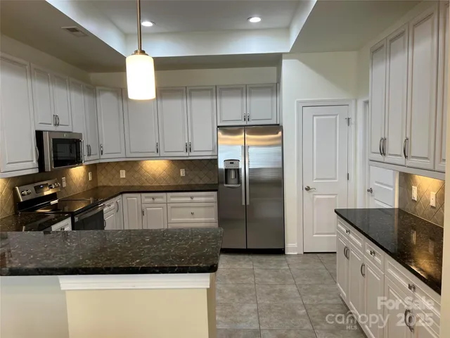 a kitchen with granite countertop a refrigerator a sink and a stove
