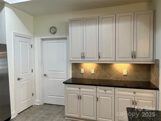 a kitchen with granite countertop white cabinets and stainless steel appliances