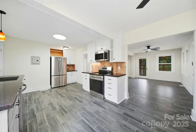 a kitchen with granite countertop a refrigerator and a stove top oven