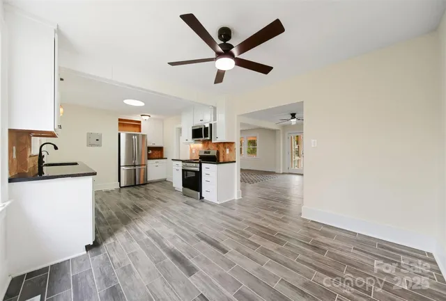 a view of kitchen with granite countertop cabinets and refrigerator