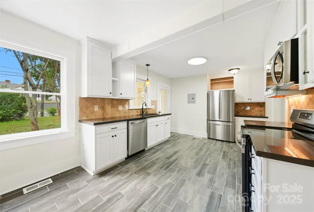a kitchen with stainless steel appliances a refrigerator sink and stove