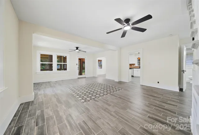 a view of a livingroom with a window and wooden floor