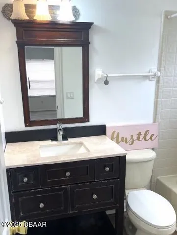 a bathroom with a toilet a sink and mirror