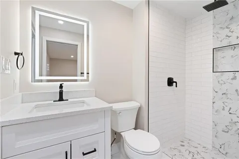 a bathroom with a sink toilet and mirror