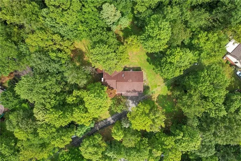 an aerial view of a house with a yard and large trees