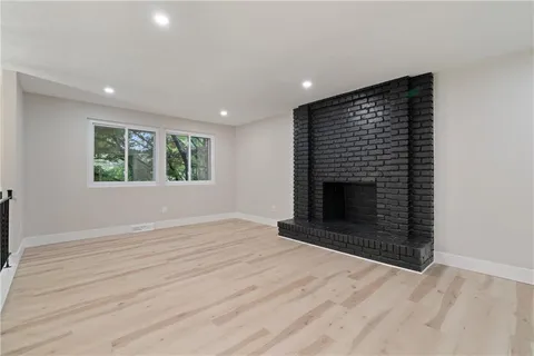 an empty room with windows and fireplace
