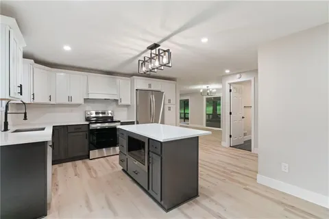 a kitchen that has a lot of cabinets in it and stainless steel appliances