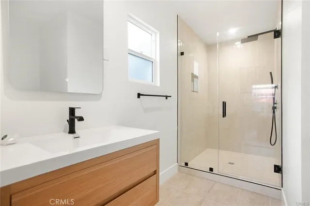 a bathroom with a shower sink and mirror