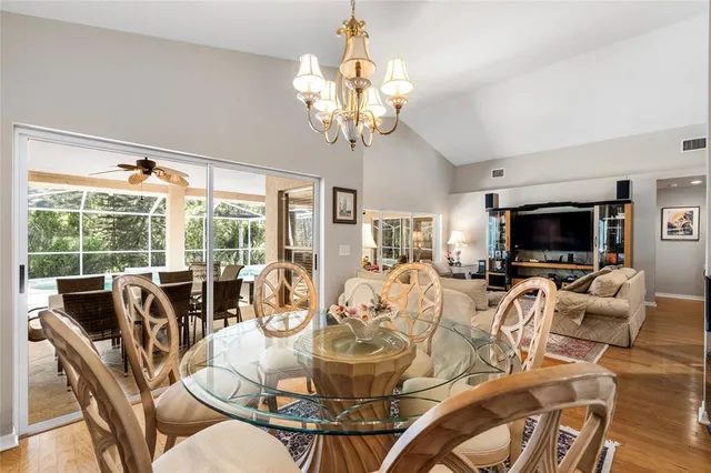 a view of a dining room with furniture a chandelier and wooden floor