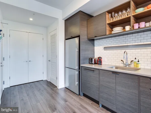 a kitchen with stainless steel appliances granite countertop a refrigerator a sink and wooden floors