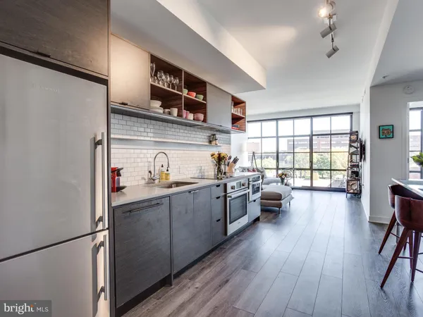 a kitchen with sink a refrigerator and wooden floor
