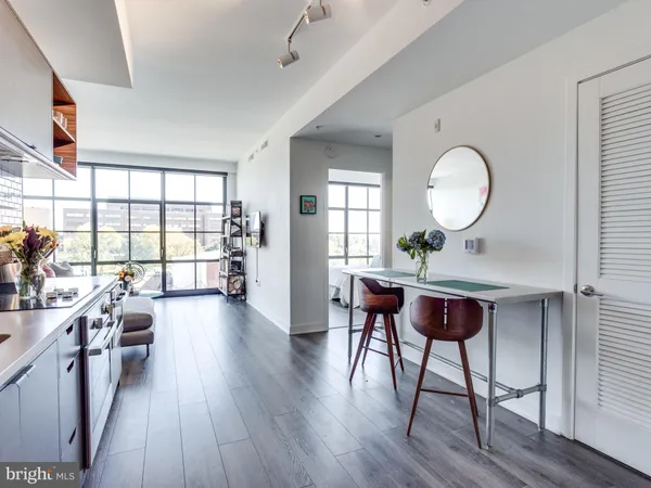 a living room with furniture a window and wooden floor