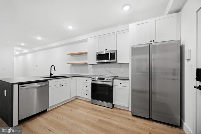 a kitchen with stainless steel appliances granite countertop a refrigerator and a sink