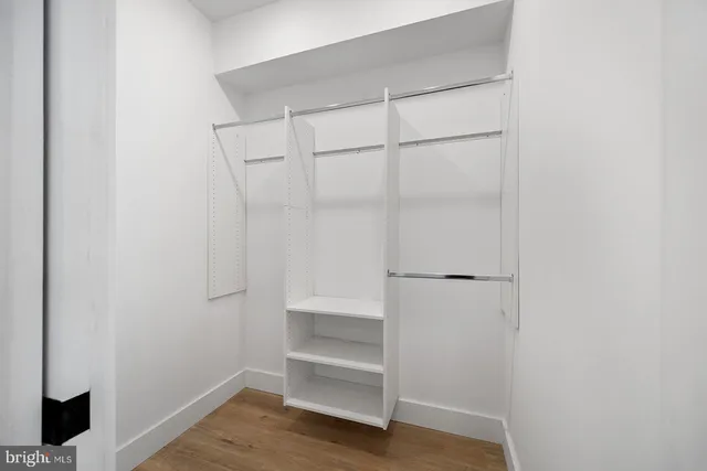 a view of walk in closet with empty racks