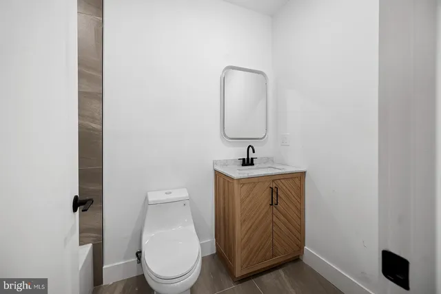 a bathroom with a toilet sink and mirror