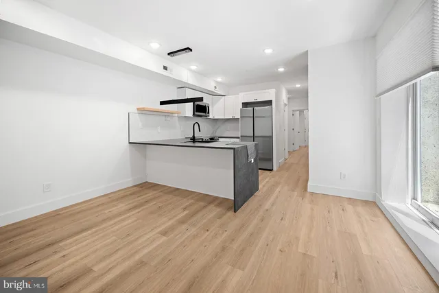 a kitchen with stainless steel appliances granite countertop a sink and a refrigerator