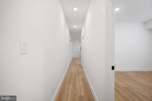a view of a hallway with wooden floor