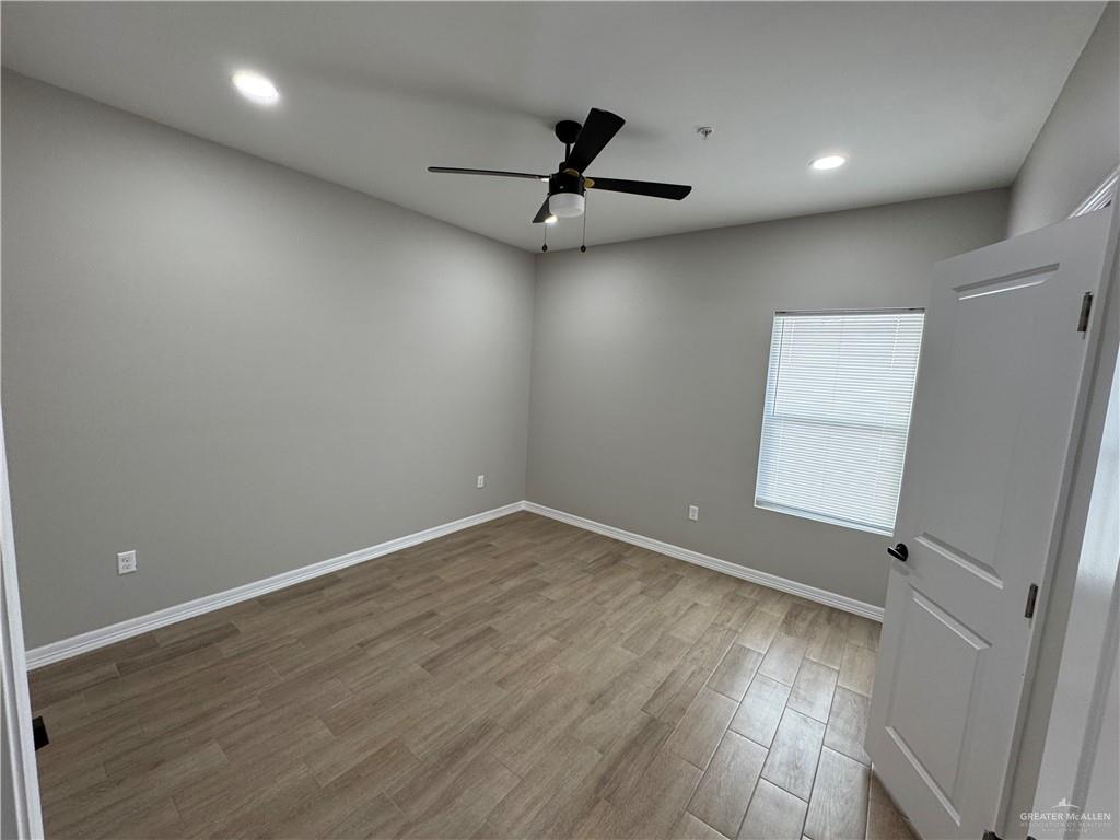 800 Ragland Road, Unit 2 Mission, TX 78572 - Photo 8 of 10 an empty room with wooden floor and windows