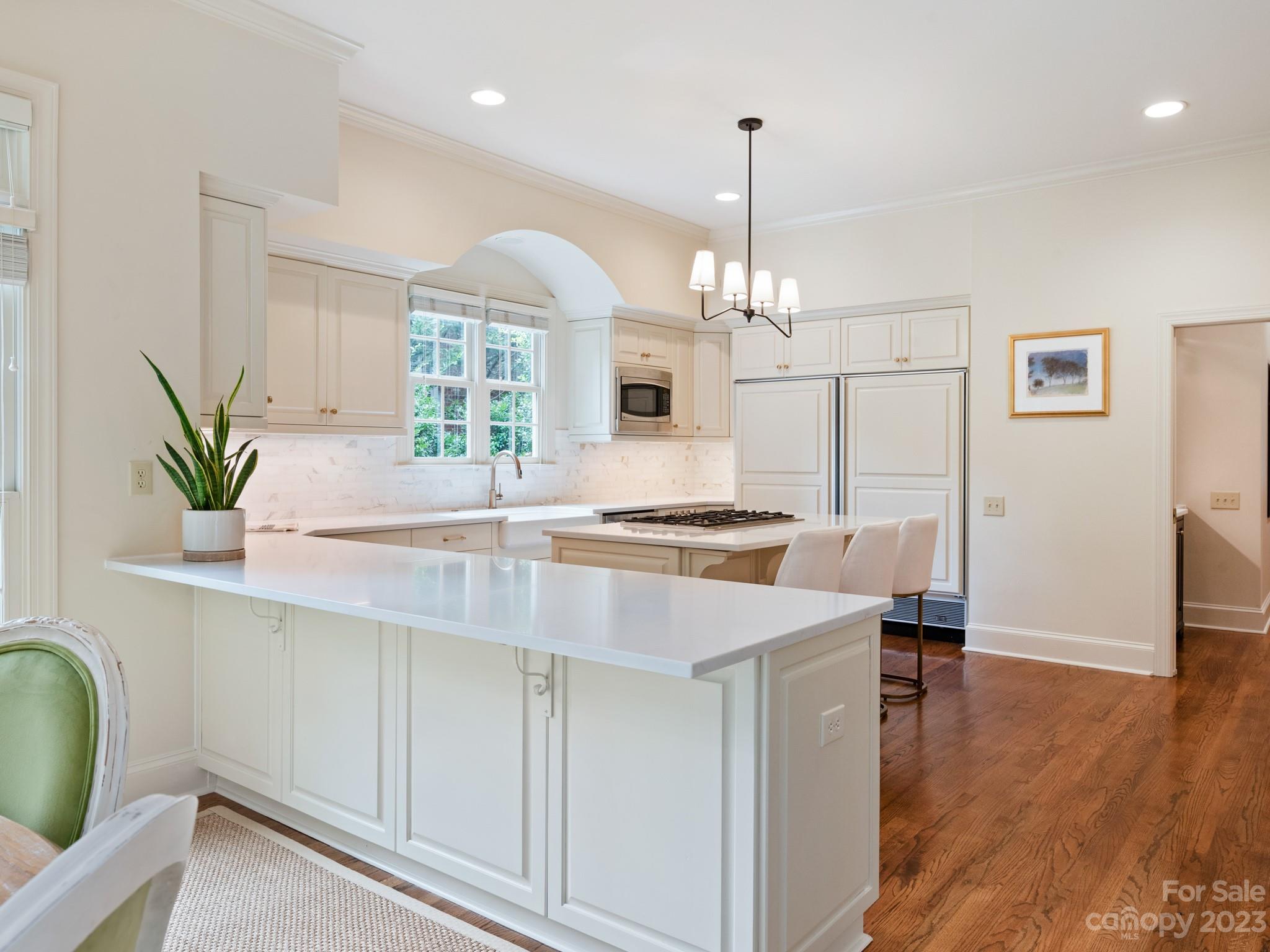 2521 Summerlake Road Charlotte, NC 28226 - Photo 22 of 48 a kitchen with stainless steel appliances a table chairs in it and wooden floors