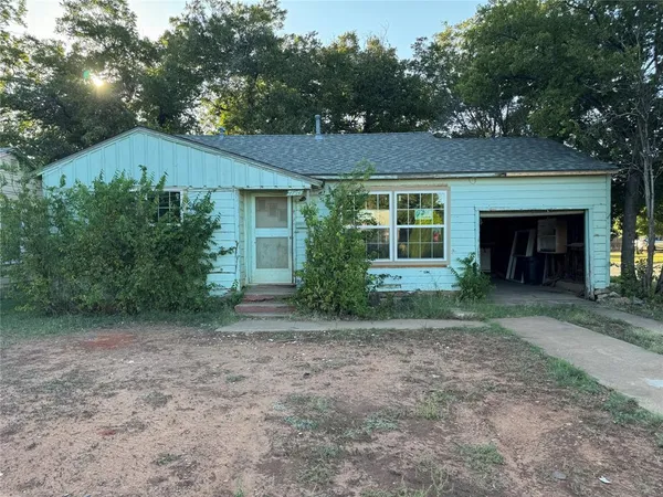 a view of a house with a yard and potted plants