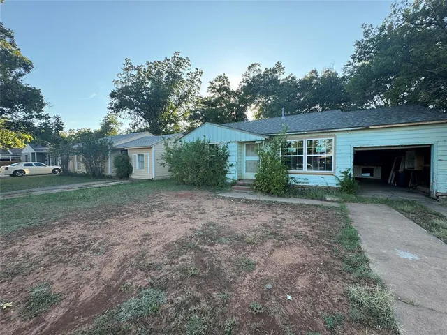 a view of a house with backyard and a garden