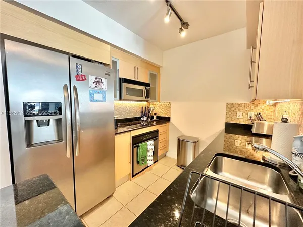 a kitchen with stainless steel appliances granite countertop a refrigerator and a sink