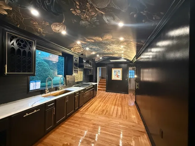 a large kitchen with stainless steel appliances a large counter top