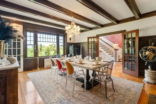 a view of a dining room and livingroom with furniture wooden floor a rug and a large window