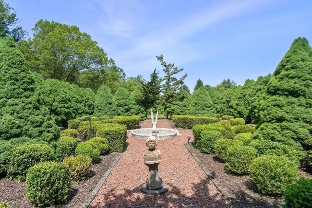 a view of a garden with lawn chairs under an umbrella