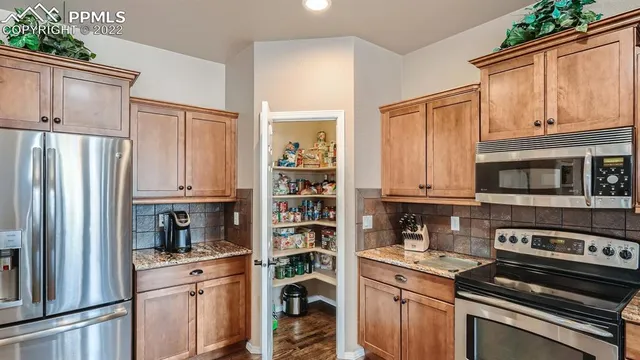 a kitchen with stainless steel appliances granite countertop a refrigerator stove and sink