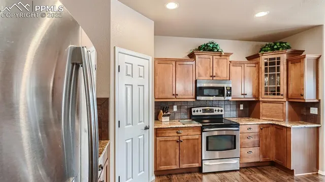 a kitchen with stainless steel appliances granite countertop a refrigerator sink and stove