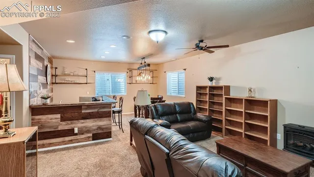 a living room with furniture a ceiling fan and a window