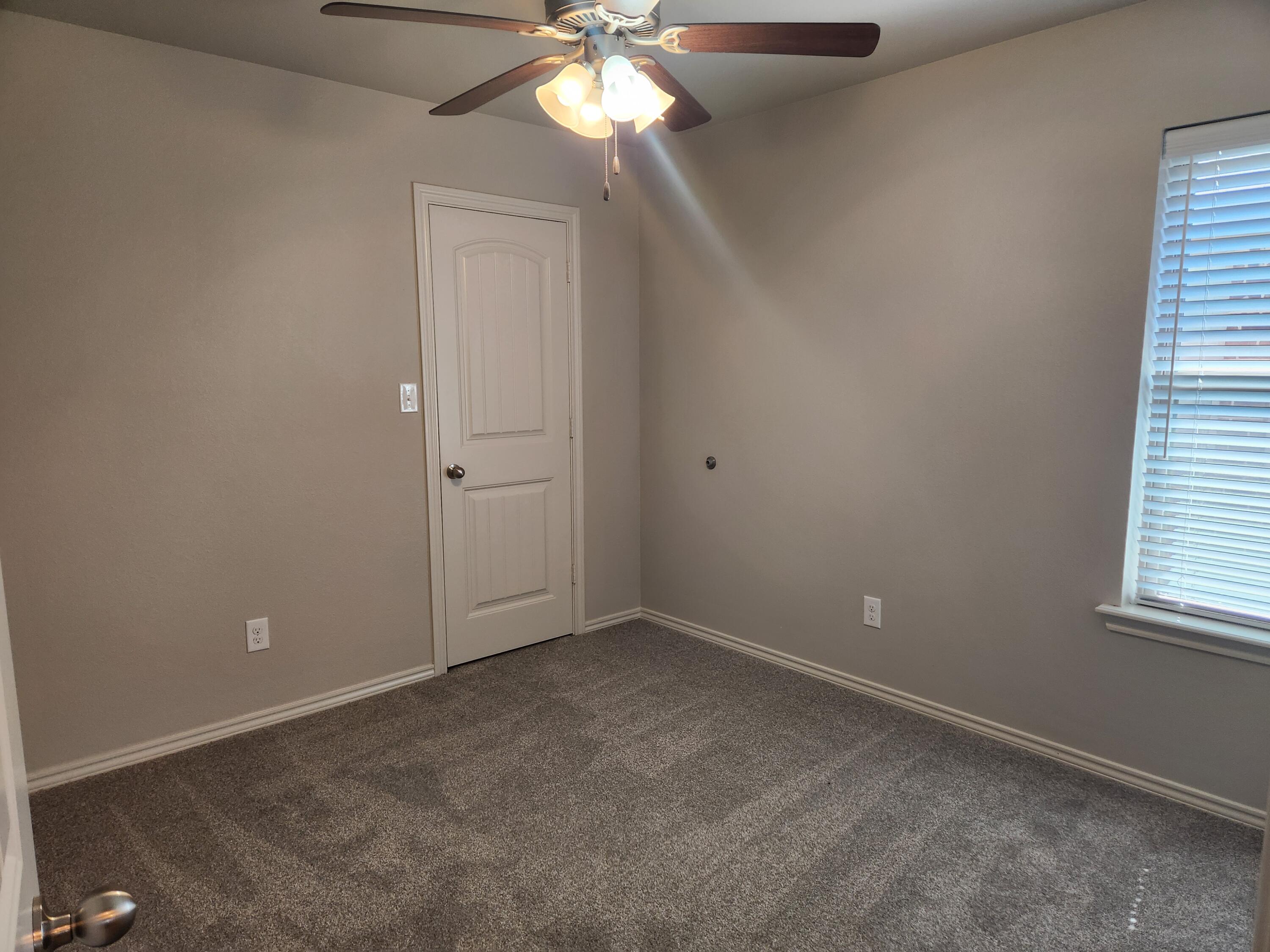 8702 13th Street Lubbock, TX 79416 - Photo 12 of 25 an empty room with windows and fan