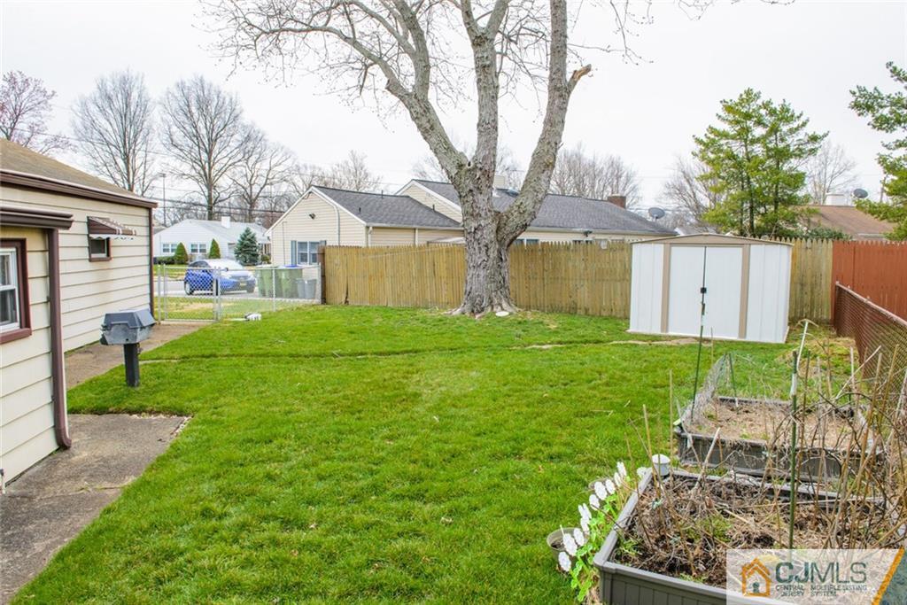 42 Colton Road Edison, NJ 08817 - Photo 3 of 6 a view of a backyard with large tree and wooden fence
