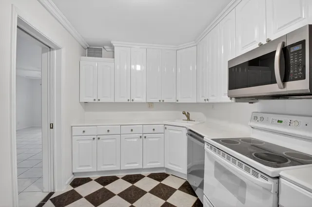 a kitchen with stainless steel appliances white cabinets and stove top oven