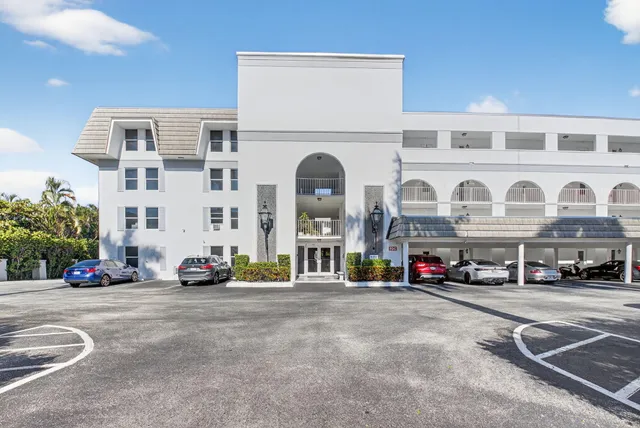 a front view of building with cars parked