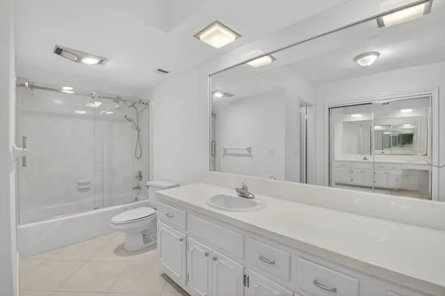 a bathroom with a bathtub shower sink mirror and toilet