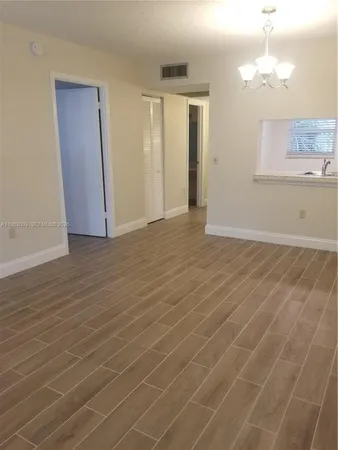 a view of a kitchen with wooden floor and a sink