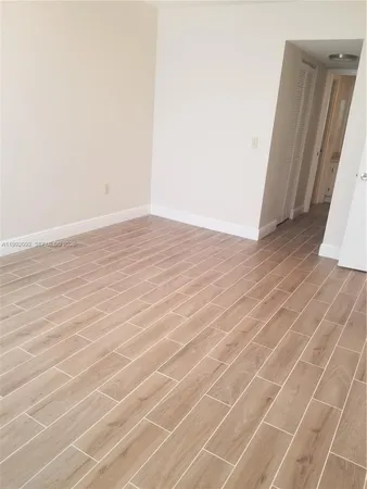 an empty room with wooden floor and white door
