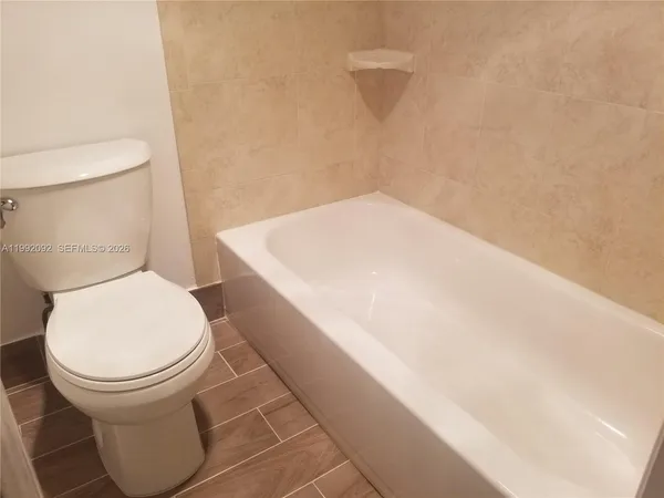 a white toilet sitting next to a white wall