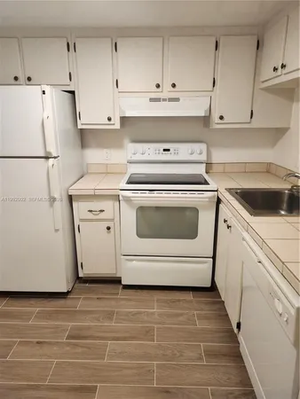 a utility room with cabinets washer and dryer
