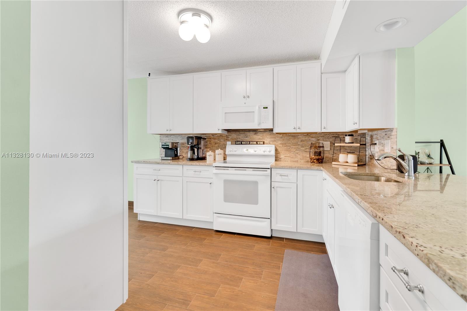 10274 Windswept Place Boca Raton, FL 33498 - Photo 7 of 33 a kitchen with cabinets appliances a sink and a counter top space