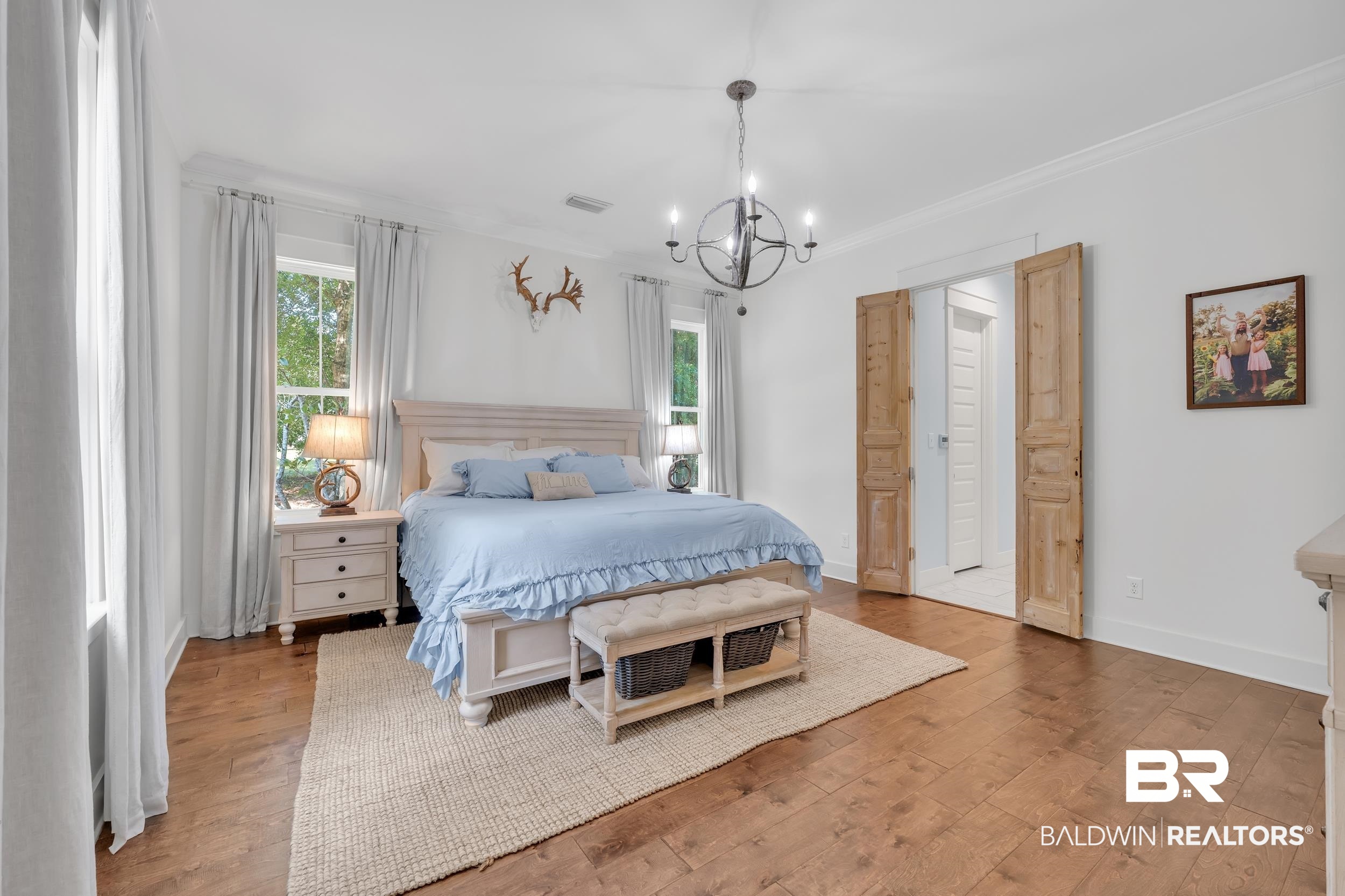 14531 Styx River Road Stapleton, AL 36578 - Photo 19 of 50 Bedroom with a chandelier, multiple windows, wood finished floors, crown molding, and baseboards
