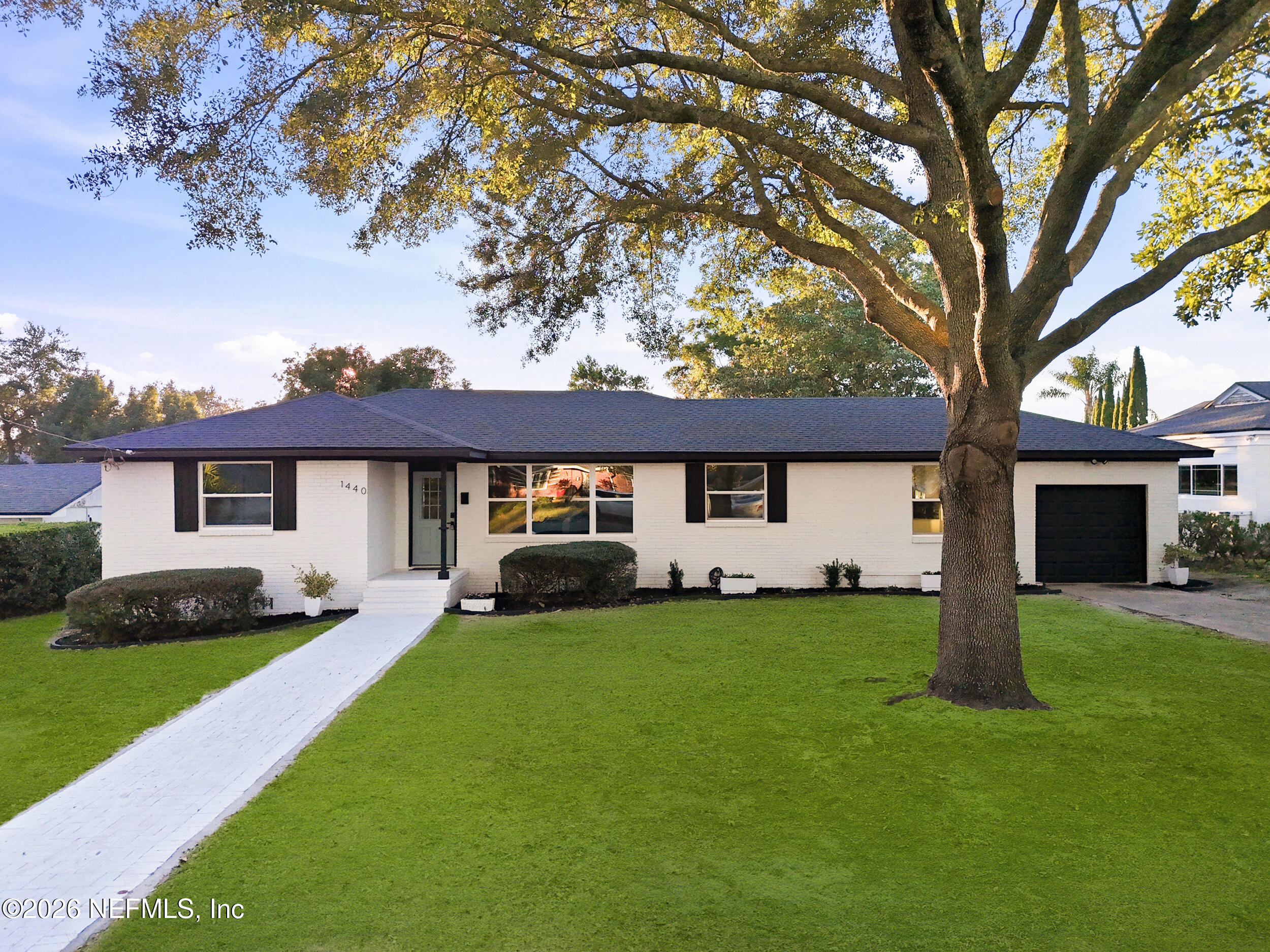 a front view of a house with a yard and trees