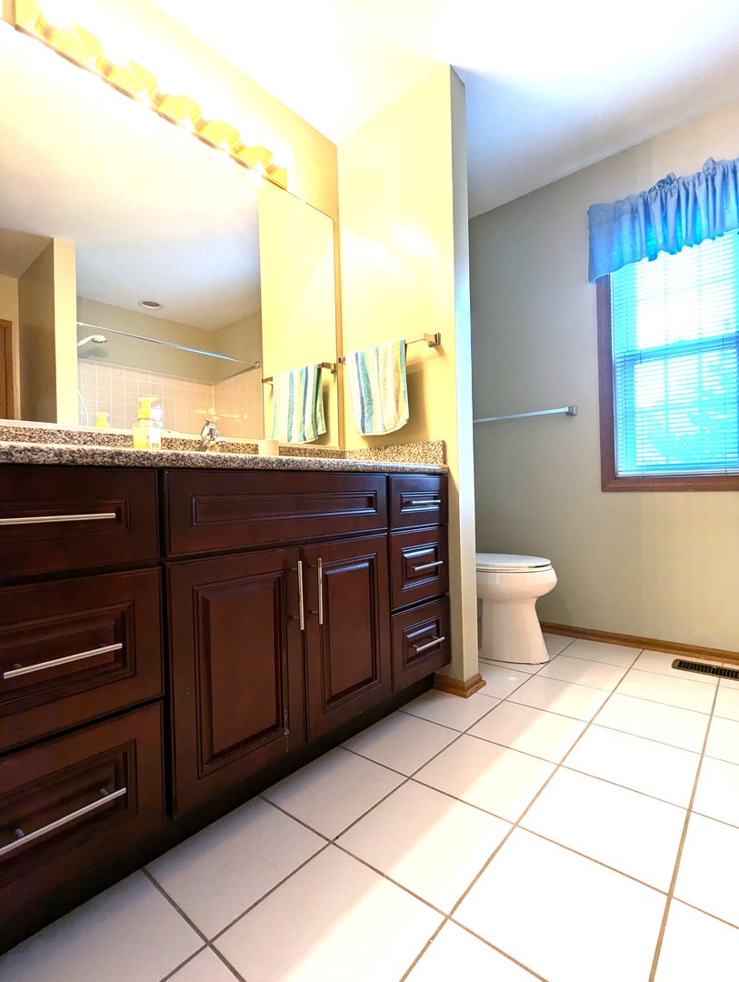 1466 Garnet Circle Hoffman Estates, IL 60192 - Photo 13 of 23 a spacious bathroom with a granite countertop sink and a toilet