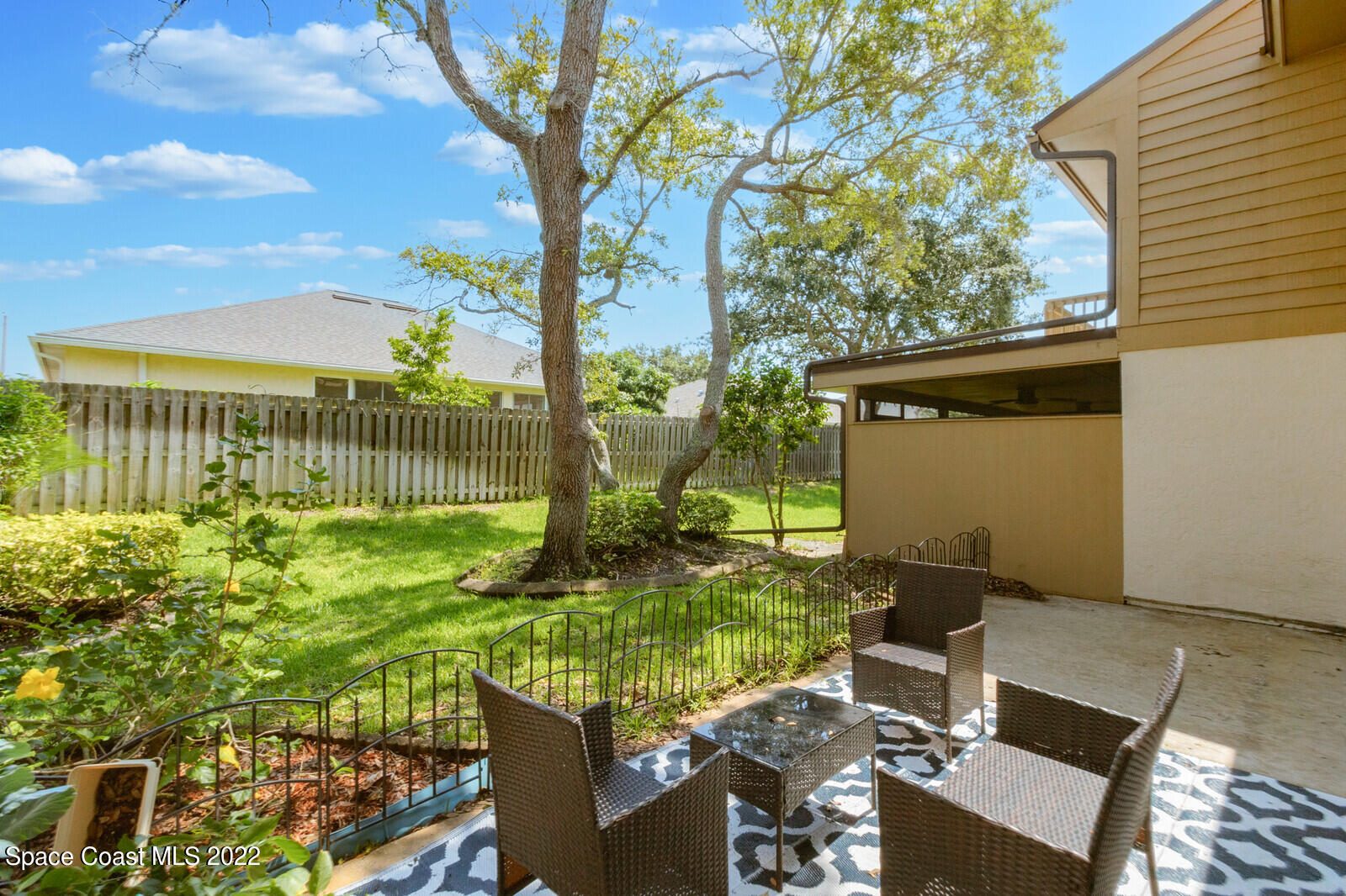 1784 Quail Trail Melbourne, FL 32935 - Photo 11 of 40 a view of backyard with a table and chair and wooden fence