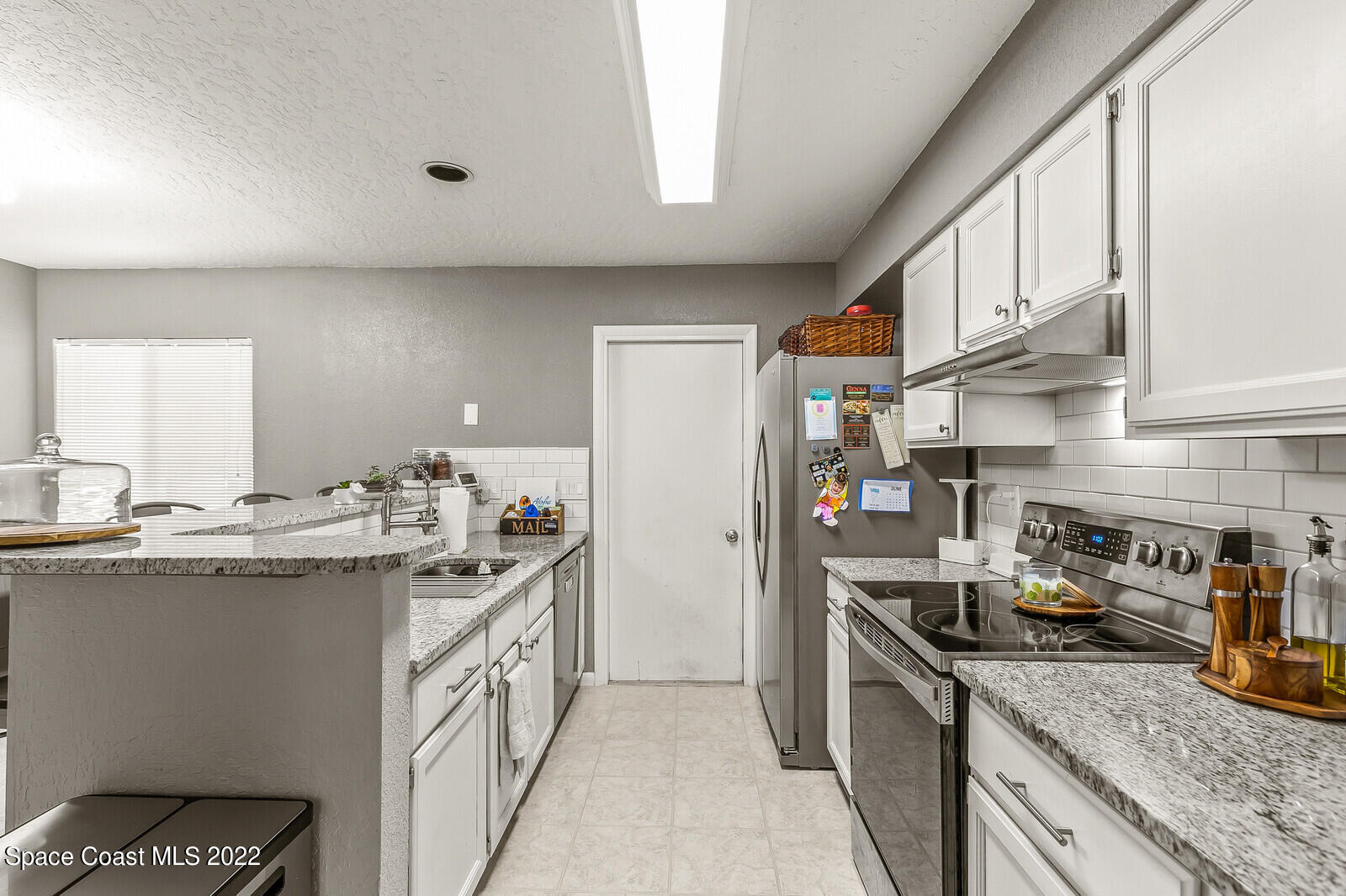 1784 Quail Trail Melbourne, FL 32935 - Photo 14 of 40 a kitchen with stainless steel appliances granite countertop a sink stove and refrigerator