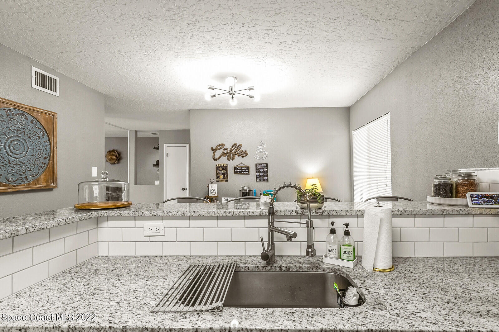 1784 Quail Trail Melbourne, FL 32935 - Photo 16 of 40 a kitchen with stainless steel appliances kitchen island granite countertop a sink and cabinets